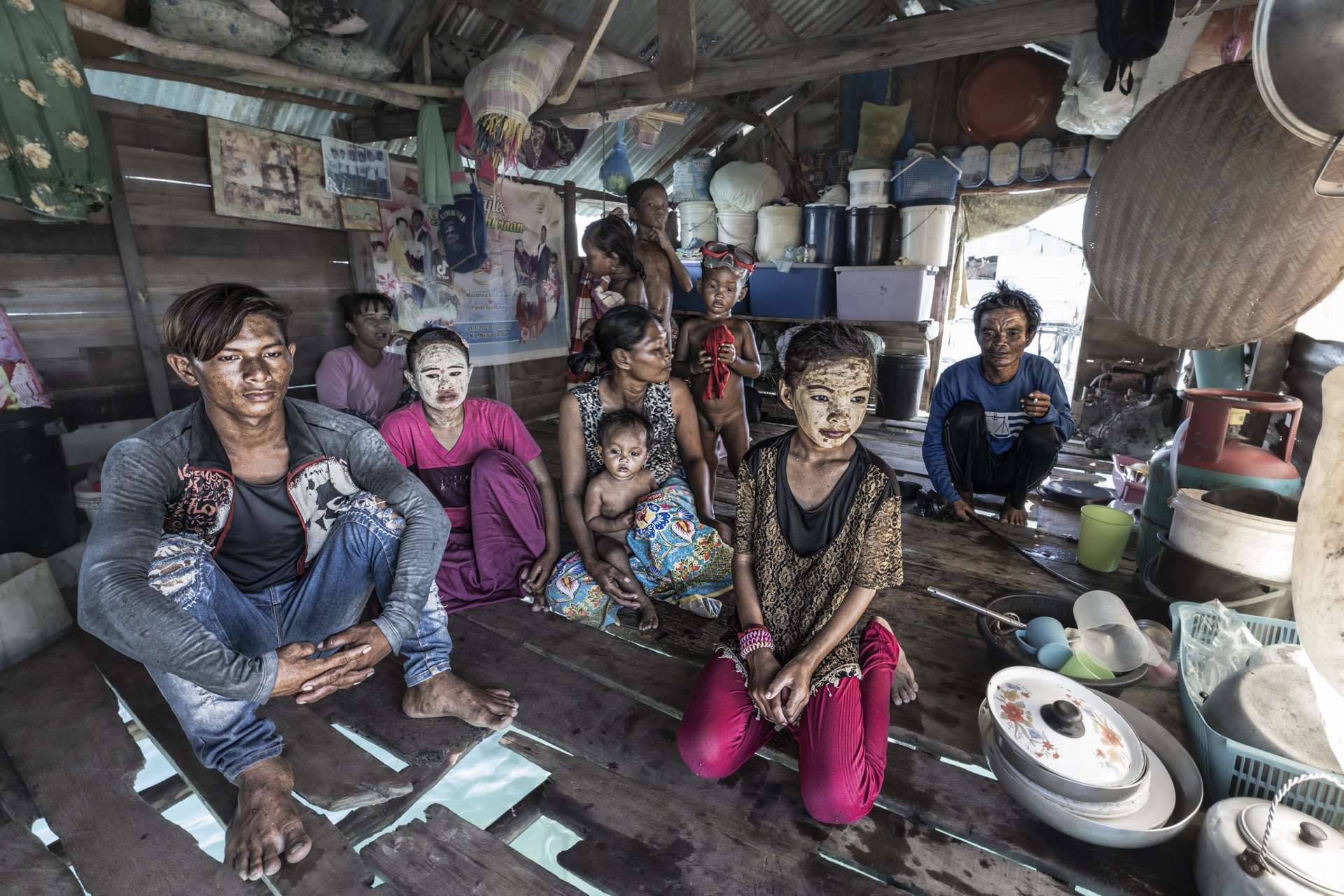 Malaysia, Omadal island, 2024-05-11. A Bajau Laut family in her stilt house. Houses are made of reclaimed materials. Pho