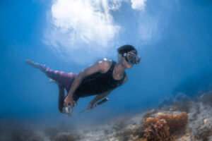 Malaysia, Omadal island, 2024-05-11. A Bajau Laut teen freediver looking for some shells or octopuses with a hook. Photo
