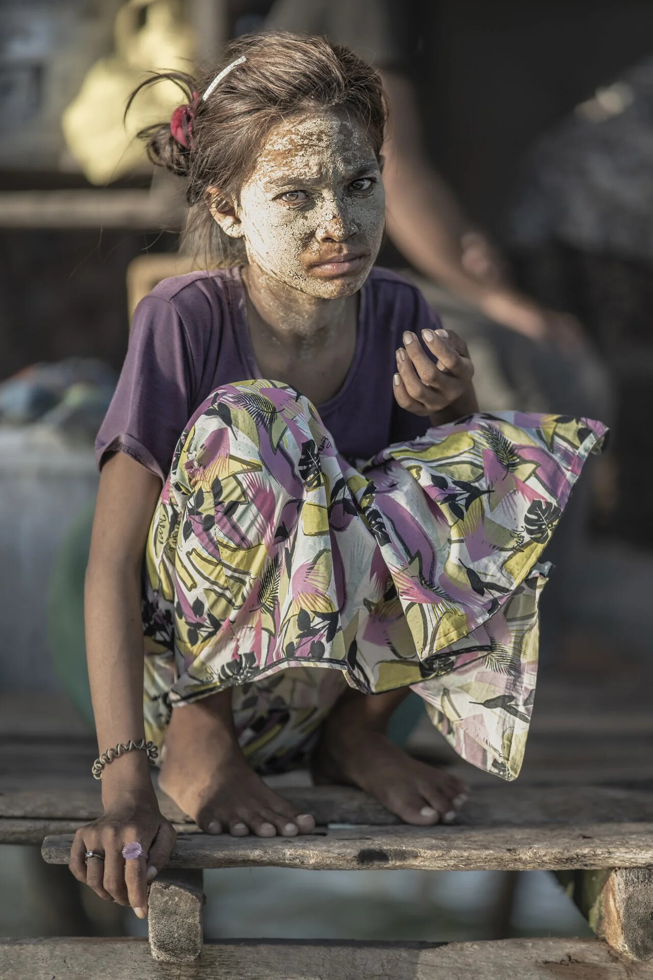 Malaysia, Boheyan island, 2024-05-10. A young Bajau Laut girl wearing a sun protection mask in front of their stilt hous