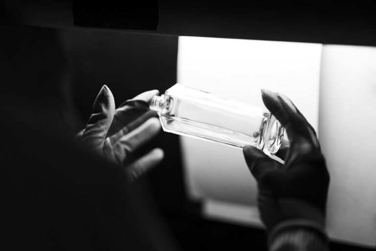 France, Longroy, 2022-03-15. A black gloved hand checks a glass vial against a white sheet during a visual quality inspe
