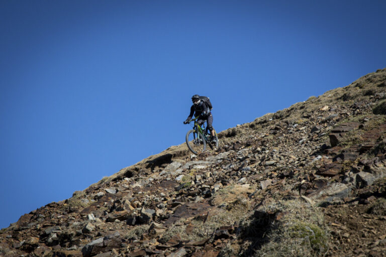 France, Bagneres-de-Bigorre, 2019-09-28. Alexis Righetti rides the highest ridges of the Pyrenees, carrying his bike whe