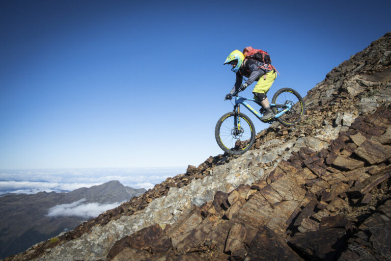 France, Bagneres-de-Bigorre, 2019-09-28. Alexis Righetti rides the highest ridges of the Pyrenees, carrying his bike whe