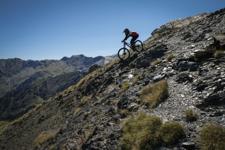 France, Aragnouet, 2017-08-12. Alexis Righetti rides the highest ridges of the Pyrenees, carrying his bike where no trai