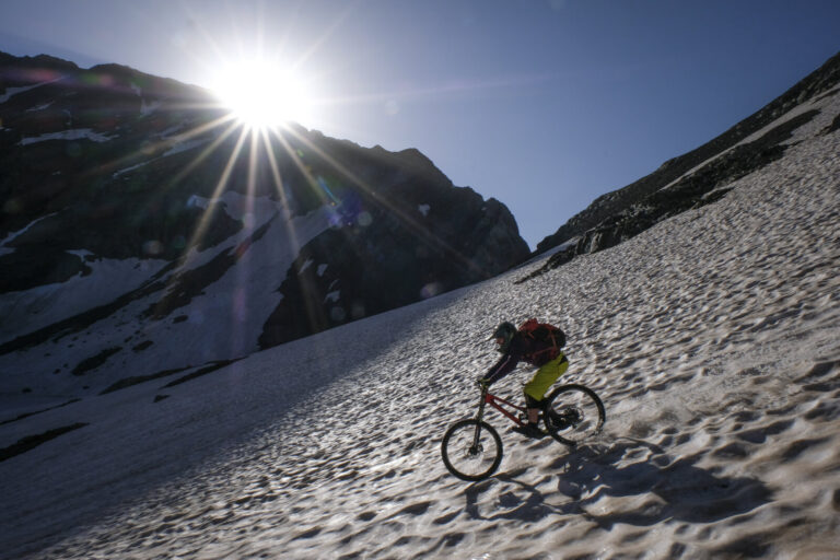 France, Aragnouet, 2018-07-01. Alexis Righetti rides the highest ridges of the Pyrenees, carrying his bike where no trai