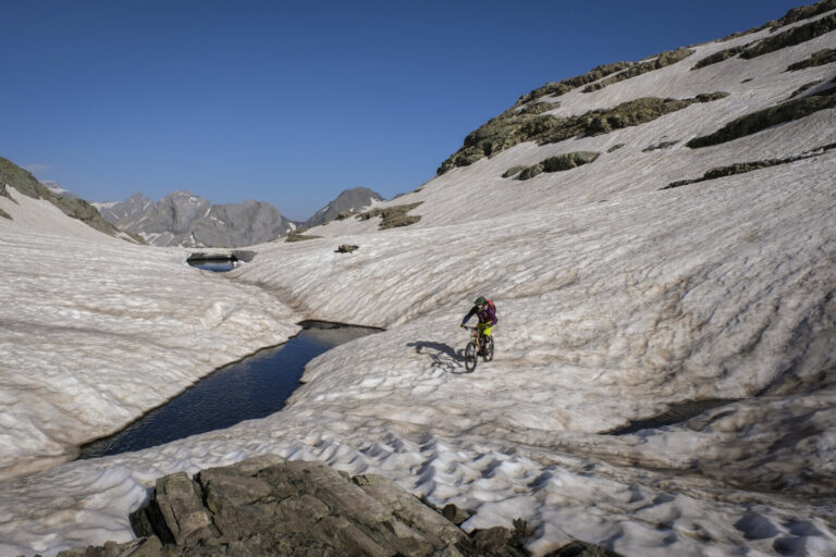 France, Aragnouet, 2018-07-01. Alexis Righetti rides the highest ridges of the Pyrenees, carrying his bike where no trai