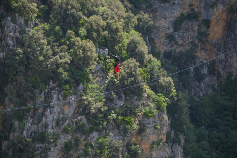 Croatia, Imotski, 2018-05-04. Above the Red Lake, a collapsed karst sinkhole near Imotski, a team rigs highlines and jum