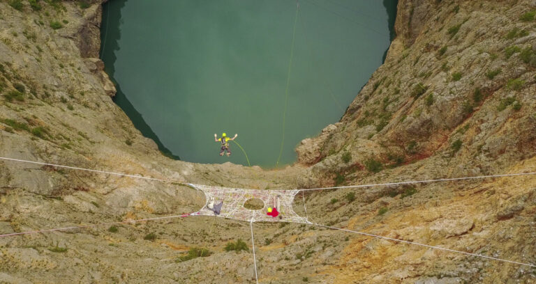 Croatia, Imotski, 2018-05-02. Above the Red Lake, a collapsed karst sinkhole near Imotski, a team rigs highlines and jum