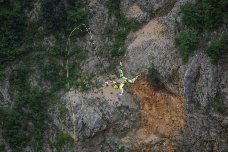 Croatia, Imotski, 2018-05-08. Above the Red Lake, a collapsed karst sinkhole near Imotski, a team rigs highlines and jum