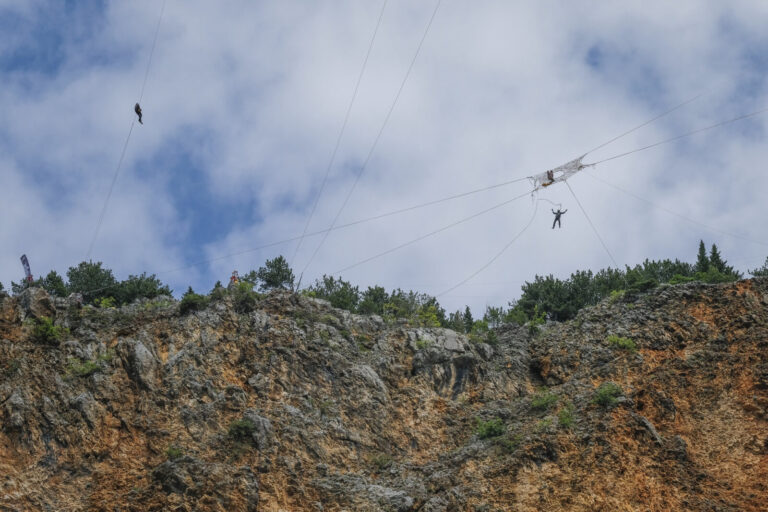 Croatia, Imotski, 2018-05-10. Above the Red Lake, a collapsed karst sinkhole near Imotski, a team rigs highlines and jum