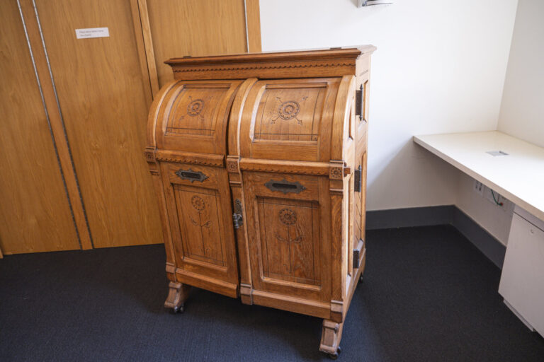 United States, New York, 2026-08-07. The antique writing cabinet standing in a modern classroom of the school. Photograp