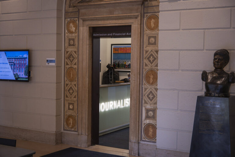 United States, New York, 2026-08-07. The admissions office of the journalism school, beside a bronze bust. Photograph by