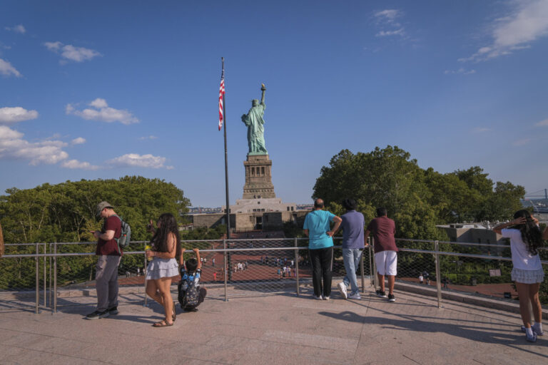 United States, New York, 2026-08-15. Visitors watch the statue from the terrace of the Statue of Liberty Museum. Photogr