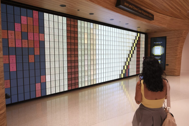 United States, Washington, 2026-08-11. A visitor in front of the wall of magazine covers arranged by colour. Photograph 