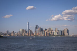 United States, New York, 2026-08-15. The skyline of Lower Manhattan seen from Liberty Island under a summer sky. Photogr