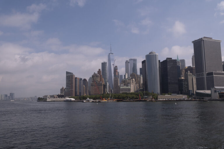 United States, New York, 2026-08-06. The tip of Lower Manhattan and Battery Park seen from the harbour. Photograph by Fr