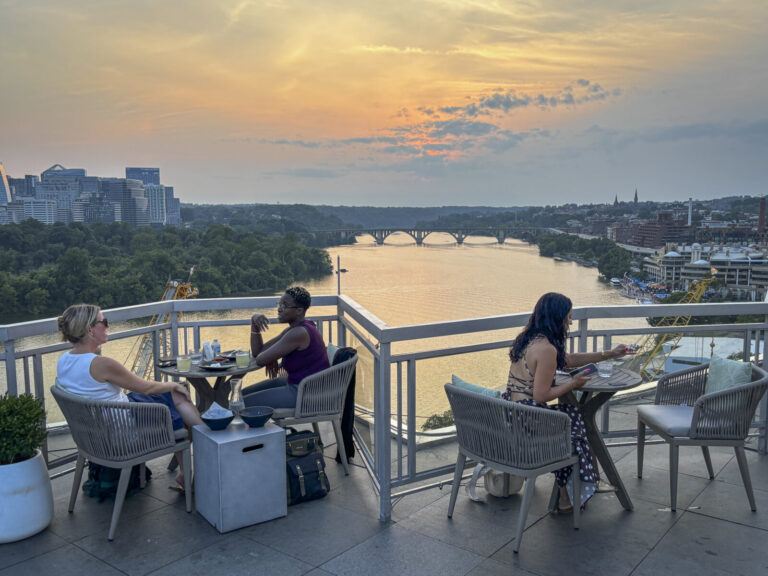 United States, Washington, 2026-08-12. Guests seated on the rooftop terrace of the Watergate Hotel at sunset. Photograph