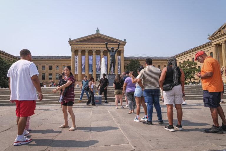 United States, Philadelphia, 2026-08-14. Visitors queue to be photographed with the Rocky statue in front of the Philade