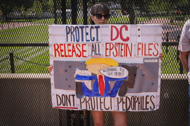 United States, Washington, 2026-08-11. A demonstrator holds a sign calling for the release of the Epstein files, in fron