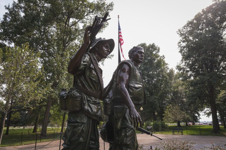 United States, Washington, 2026-08-11. The Three Servicemen statue and the American flag of the Vietnam Veterans Memoria