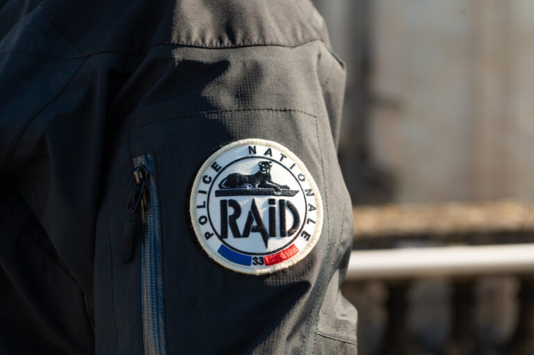 France, Bordeaux, 2025-01-31. A RAID sniper moves discreetly across the rooftops of a historic building in an urban envi
