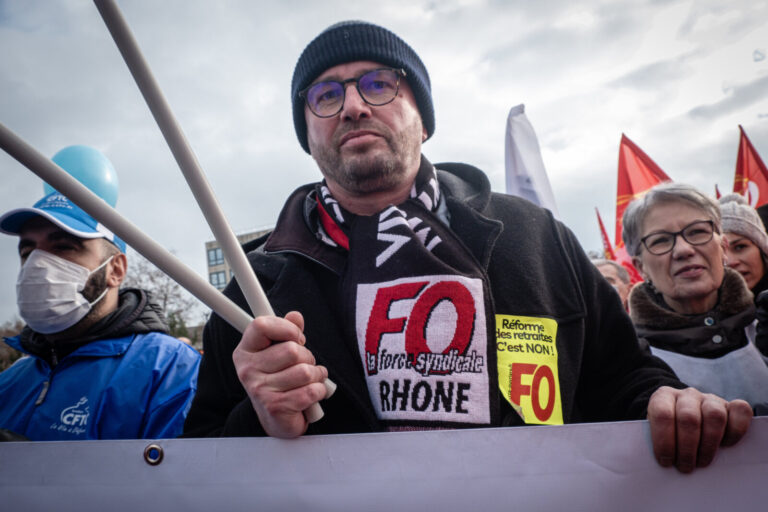 France, Lyon, 2023-01-19. Demonstration against the government's pension reform. A Force Ouvriere demonstrator behind th