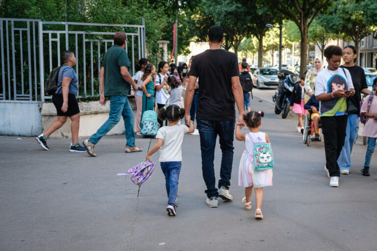 France, Lyon, 2022-09-01. A man holding two little girls by the hand on the first day of school.
Photograph by Franck CH