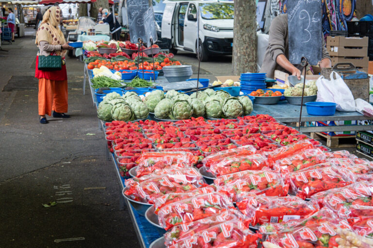France, Lyon, 2022-05-13. Fruit and vegetables on a food market stall on quai saint antoine with a customer from the bac