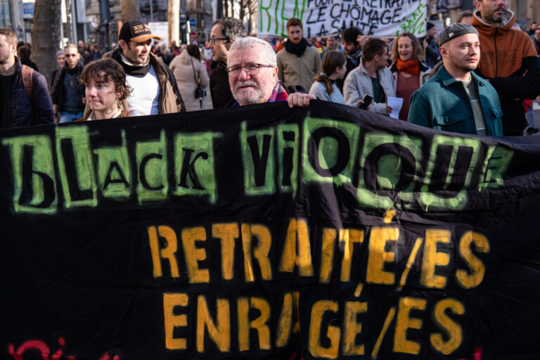 France, Lyon, 2023-02-16. Demonstration against the pension reform. A man with a black vioque banner enrages pensions. P