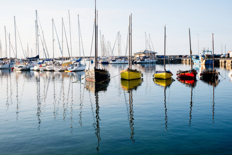 France, Lesconil, 2026-08-03. The port of Lesconil, with boats and old sailing vessels lined up, their reflections visib