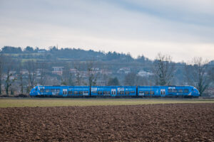 France, Civrieux d Azergues, 2024-01-30. A blue TER from the Auvergne Rhone Alpes region passing a village and farmland.