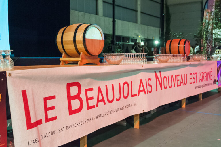 France, Beaujolais, 2015-11-20. A table with barrels, glasses and a banner le beaujolais nouveau has arrived for a tasti
