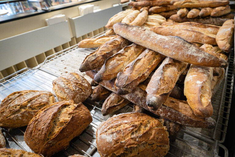 France, Lyon, 2022-09-30. Baguettes and balls of bread coming out of the oven at a baker's. Photograph by Franck CHAPOLA