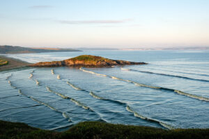 France, Plonevez Porzay, 2024-08-05. View of the island of Salgren with the beach and ocean waves at high tide. Photogra