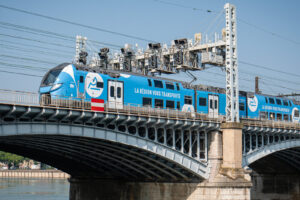 France, Lyon, 2025-06-12. A TER from the Auvergne Rhone Alpes region on a bridge over the Rhone with railway signal ligh
