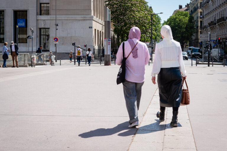France, Lyon, 2026-04-27. Two women seen from behind wearing hijabs walking down the street. Photograph by Franck CHAPOL