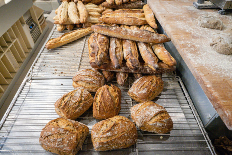 France, Lyon, 2022-09-30. Baguettes and balls of bread coming out of the oven at a baker's. Photograph by Franck CHAPOLA