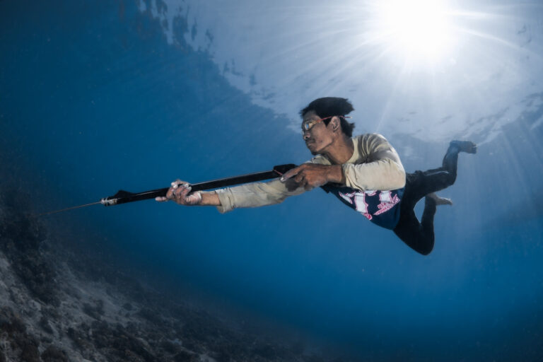 Malaysia, Denawan, 2024-05-09. Bajau Laut man spearfishing in the reef with traditional gogles. Photograph by Gilles Aur
