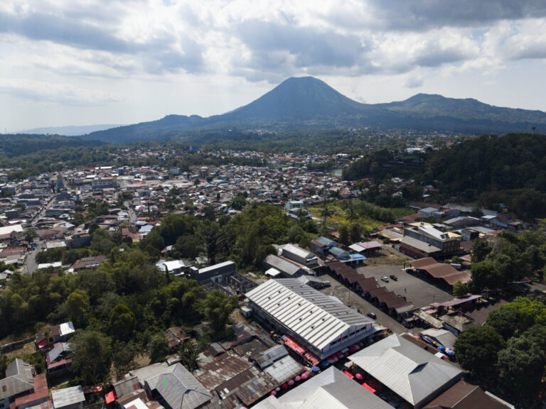 Indonesia, Tomohon, 2026-09-11. Aerial overview of the Tomohon market complex, with long metal-roofed buildings and an a