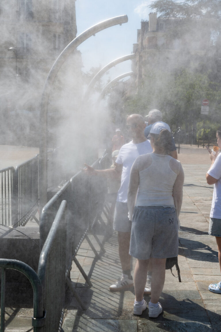 France, Paris, 2026-06-21. Under the heatwave, residents and passersby cool off under public misting devices or seek ref