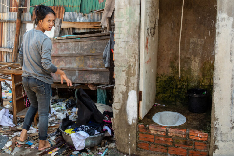 Cambodia, Phom Penh, Tuol Kok, 2019-11-29. A woman sorts rubbish next to the toilet in her house. Photograph by Guy LERO