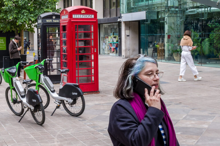 England, London, 2023-06-05. A typical phone booth surrounded by passers-by using smartphones. Photo by Guy LEROY / Coll