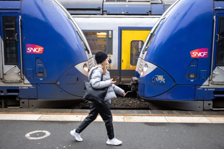 France, Lille, 2022-12-22. A passenger walks on a platform alongside a train. Photograph by Guy LEROY / Collectif DR.Fr