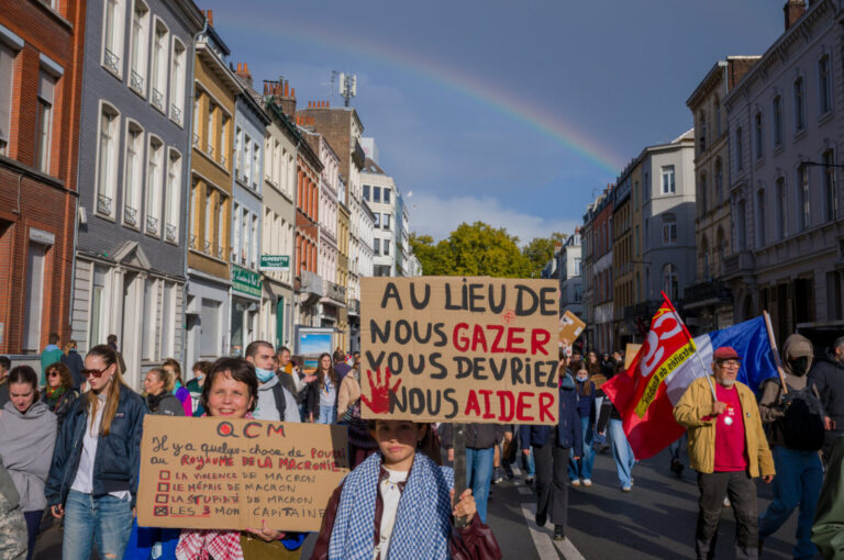 France, Lille, 2026-10-17. Protesters carry signs calling for help instead of gas and criticising Macron, with flags and