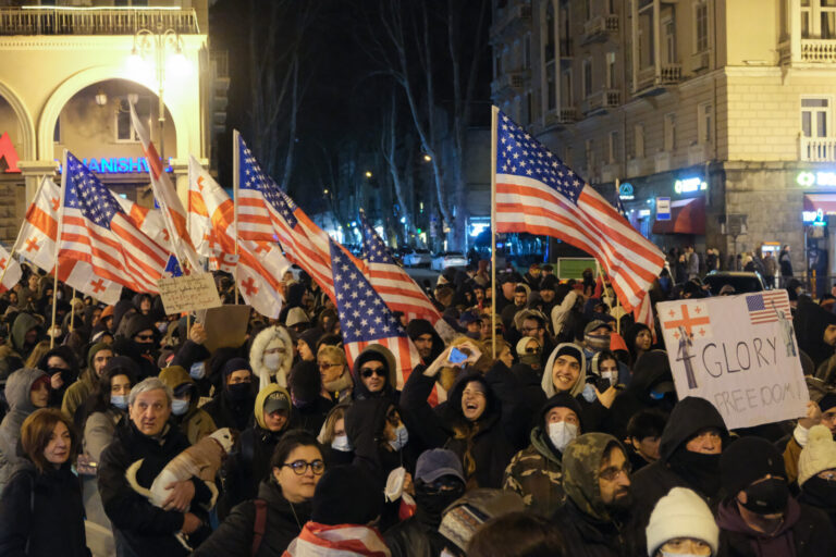 Georgia, Tbilisi, 2025-03-22. Protesters are carrying flags of Georgia and the USA and a sign that reads "Glory to freed
