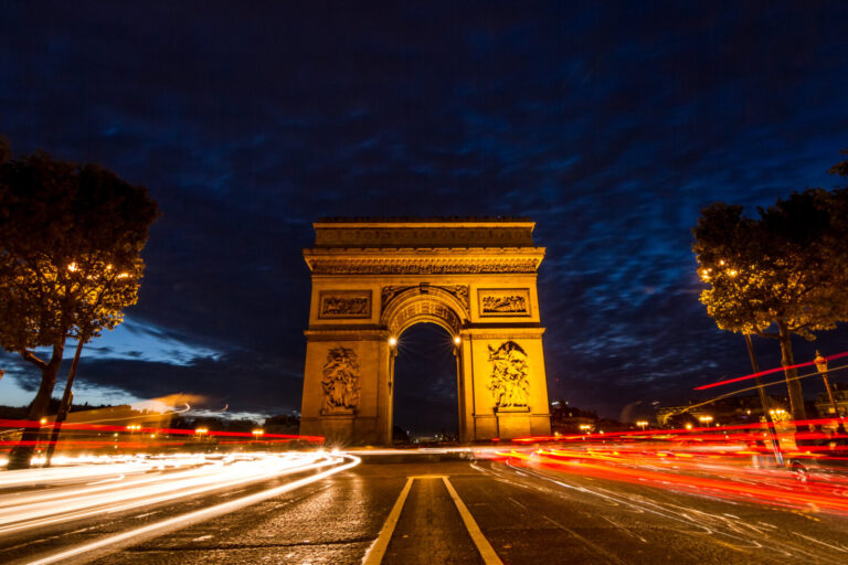France, Paris, 2013-10-18. France, Paris. The Arc de Triomphe stands illuminated against a dramatic twilight sky, with g