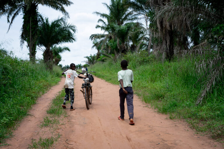Democratic Republic of Congo, Kasai Oriental, 2024-11-03. Children travel with a bicycle on a service road used for agri