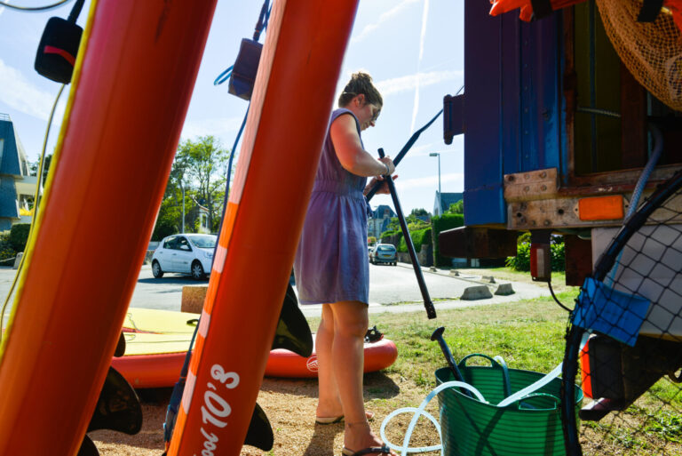 France, Saint-Quay-Portrieux, 2022-07-14. A young woman looks at the state of a paddle. Aboard the Homard Flottant, an e