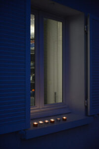 France, Digoin, 2020-12-14. Petites bougies sur le rebord d'une fenetre, a la tombee de la nuit pour la fete des lumiere