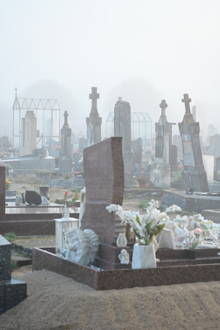 France, Digoin, 2026-10-16. Several graves, with marble, stone topped with a cross, and glass headstones, in a cemetery,