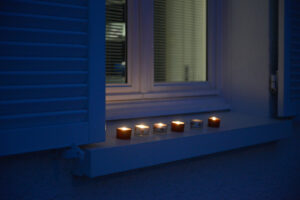 France, Digoin, 2020-12-14. Petites bougies sur le rebord d'une fenetre, a la tombee de la nuit pour la fete des lumiere